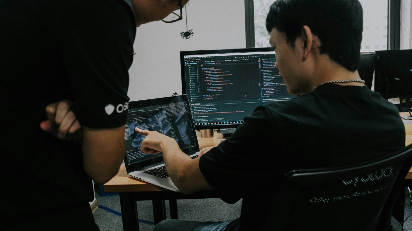 A mentor and student working together on computer code. Photo by Shamin Haky on Unsplash.