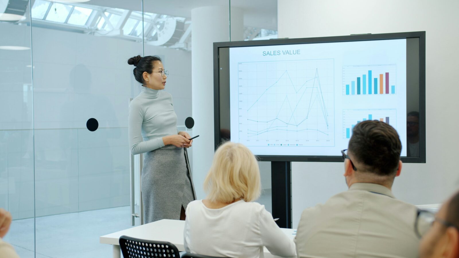 Business person leading a presentation in a bright, open room. Photo by Vitaly Gariev on Unsplash.