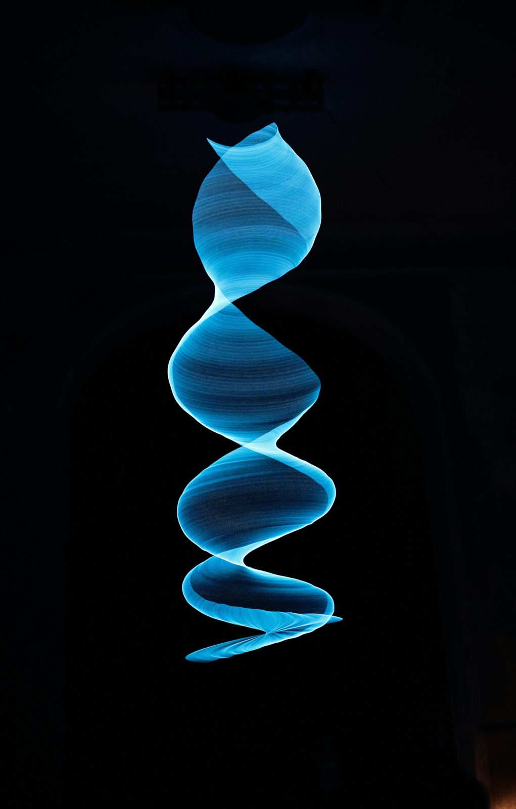 A blue spiral on a black background. Photo by Marcus Ganahl on Unsplash.